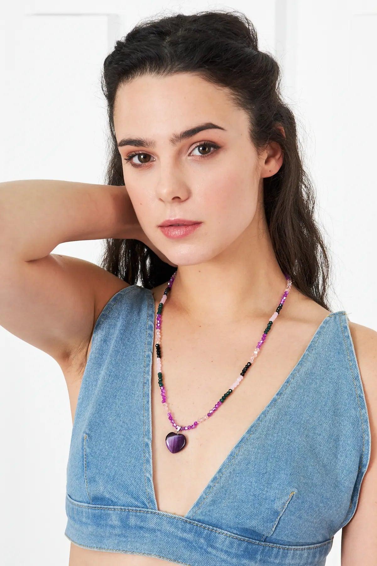 A stunning necklace featuring an amethyst heart-shaped pendant with faceted crystal beads in purple and pink tones, perfect for adding elegance to any outfit.