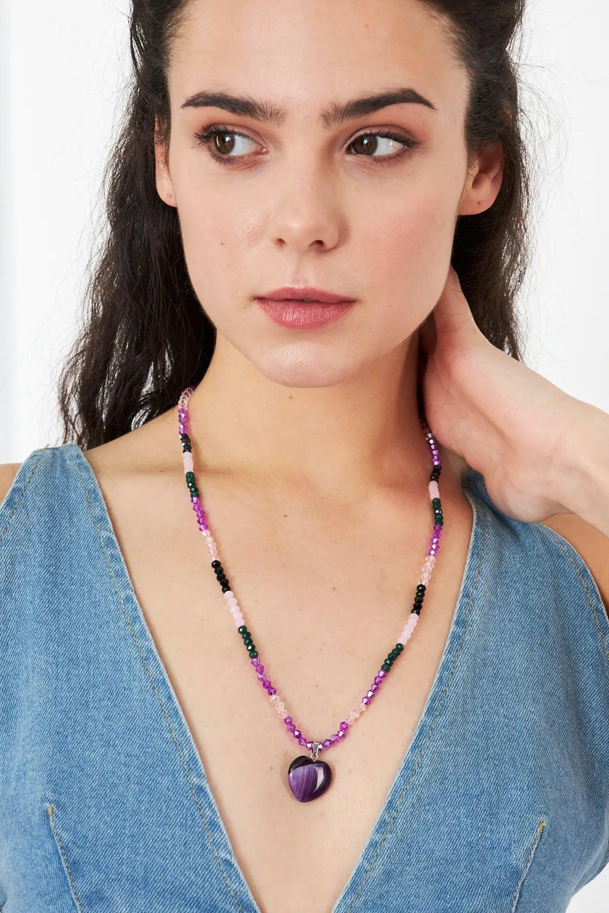 A stunning necklace featuring an amethyst heart-shaped pendant with faceted crystal beads in purple and pink tones, perfect for adding elegance to any outfit.