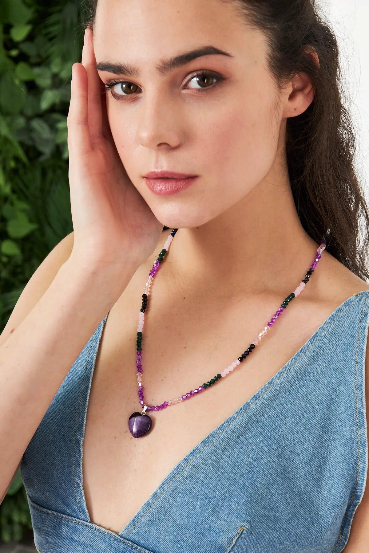 A stunning necklace featuring an amethyst heart-shaped pendant with faceted crystal beads in purple and pink tones, perfect for adding elegance to any outfit.