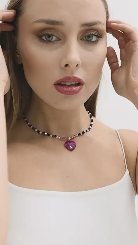 A stunning necklace featuring an amethyst heart-shaped pendant with faceted crystal beads in purple and pink tones, perfect for adding elegance to any outfit.